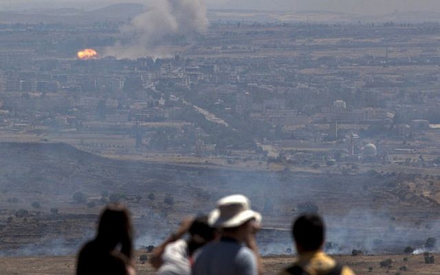 Israelis and tourists look at a fire, caused by fighting in Syria, from an observation point on Mt. Bental in the Golan Heights, near the border between the Golan Heights and Syria, Friday, June 7, 2013. (photo credit: AP/Sebastian Scheiner) Israelis and tourists look at a fire, caused by fighting in Syria, from an observation point on Mt. Bental in the Golan Heights, near the border between the Golan Heights and Syria, Friday, June 7, 2013. (photo credit: AP/Sebastian Scheiner)