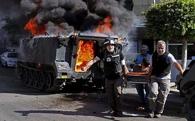 Medics transport an injured Lebanese soldier after clashes between followers of a radical Sunni cleric Sheik Ahmad al-Assir and Shiite gunmen, in the southern port city of Sidon, Lebanon, on Sunday, June 23, 2013. (photo credit: AP Photo/Mohammed Zaatari)
