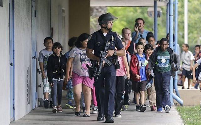 A Santa Monica police officer leads children on a field trip from Citizens of the World Charter School in Los Angeles out of Santa Monica College, where they had gone for a planetarium show, following a shooting in the area in Santa Monica, California on Friday. (photo credit: AP Photo/Reed Saxon) A Santa Monica police officer leads children on a field trip from Citizens of the World Charter School in Los Angeles out of Santa Monica College, where they had gone for a planetarium show, following a shooting in the area in Santa Monica, California on Friday. (photo credit: AP Photo/Reed Saxon)