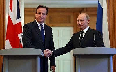 British Prime Minister David Cameron (l) shakes hands with Russian President Vladimir Putin, during a press conference in London on Sunday June 16, 2013. (photo credit: Anthony Devlin, PA Wire/AP)