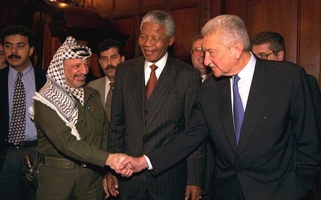 Israeli president Ezer Weizman shakes hands with Palestinian leader Yasser Arafat in Johannesburg, while South African president Nelson Mandela looks on, May 9, 1994. (photo credit: Yaacov Sa'ar/GPO)