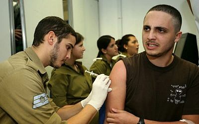 An Israeli recruit on his first day of military service gets a vaccine injection (photo credit: Moshe Shai/Flash90)