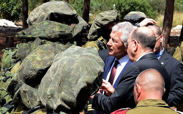 US Secretary of Defense Chuck Hagel, center, and Israeli Defense Minister Moshe Ya'alon, on Hagel's left, visit a group of female IDF soldiers belonging to the Oketz canine unit, in April (photo credit: Matty Stern/US Embassy/Flash90)