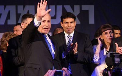 Prime Minister Benjamin Netanyahu waves to supporters after the exit polls in the general elections were announced, January 22, 2013. Standing to his left, applauding, is Likud MK Danny Danon. (Photo credit: Miriam Alster/Flash90)