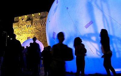 Spectators gaze at 'Spirit Light of the Forest,' created in Montreal by Lucion Media. Located in front of Jaffa Gate, seven huge bubbles come together to form a mosaic of light and shadow (photo credit: Leeor Bronis/Times of Israel)