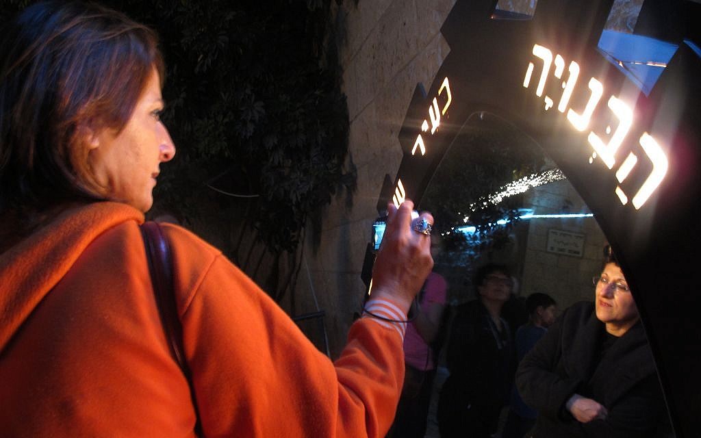 Part of the “Light in the Shadow” exhibit by artist Dan Groover, guests can read inscriptions carved on multiple mirrors and light fixtures (photo credit: Leeor Bronis/Times of Israel)