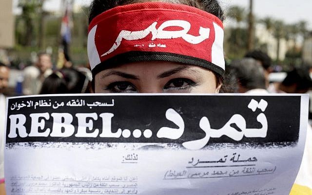 An Egyptian activist covers her face with an applications for "Tamarod," Arabic for "rebel," a campaign calling for the ouster of Egyptian President Mohammed Morsi and for early presidential elections, during a protest in Tahrir Square in Cairo, Egypt. No matter what happens in anti-Morsi protest planned for June 30, 2013, organizers of the petition campaign that led to it say they have created a grassroots network of new activists they hope will remain a voice for the public. (photo credit: AP/Hassan Ammar) An Egyptian activist covers her face with an applications for "Tamarod," Arabic for "rebel," a campaign calling for the ouster of Egyptian President Mohammed Morsi and for early presidential elections, during a protest in Tahrir Square in Cairo, Egypt. No matter what happens in anti-Morsi protest planned for June 30, 2013, organizers of the petition campaign that led to it say they have created a grassroots network of new activists they hope will remain a voice for the public. (photo credit: AP/Hassan Ammar)