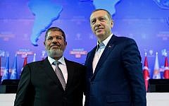 Turkey's Prime Minister Recep Tayyip Erdogan, right, and Egypt's former president Mohammed Morsi salute the members of Turkey's ruling Justice and Development Party in Ankara, Turkey in Sept. 2012 (photo credit: AP/Kayhan Ozer)