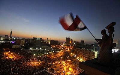 An Egyptian protester waves the national flag over Tahrir Square, the focal point of the Egyptian uprising,  June 28, 2013.  massive nationwide protests planned by the opposition this weekend demanding Mohammed Morsi's removal. (AP Photo/Amr Nabil)