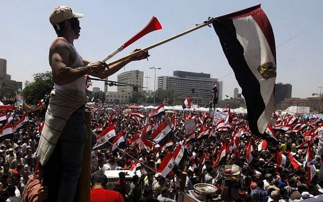 Egyptian protesters chant slogans and wave national flags in Tahrir Square, the focal point of the Egyptian uprising, in Cairo, on Sunday, June 30, 2013. (photo credit: AP/Amr Nabil) Egyptian protesters chant slogans and wave national flags in Tahrir Square, the focal point of the Egyptian uprising, in Cairo, on Sunday, June 30, 2013. (photo credit: AP/Amr Nabil)