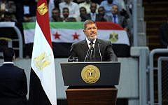 Egyptian President Mohammed Morsi addresses a rally called by hardline Islamists to show solidarity with the people of Syria, in a stadium in Cairo, Sunday, June 15, a day after he announced that he was cutting off diplomatic relations with Syria. (photo credit: AP Photo/Egyptian Presidency)