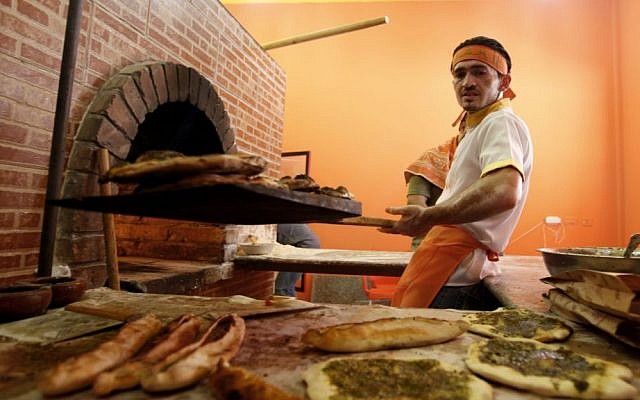 An employee at "Damashki" (or "The Guy From Damascus") bakery co-owned by Bassel Shunar, a Palestinian by origin who was born in Syria but who fled the country and arrived in the Gaza Strip two months ago. (photo credit: AP Photo/Hatem Moussa) An employee at "Damashki" (or "The Guy From Damascus") bakery co-owned by Bassel Shunar, a Palestinian by origin who was born in Syria but who fled the country and arrived in the Gaza Strip two months ago. (photo credit: AP Photo/Hatem Moussa)
