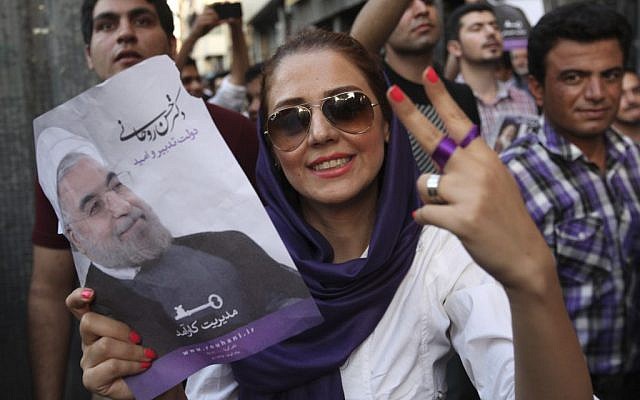 A female supporter of Iranian presidential candidate Hasan Rowhani flashes a victory sign as she holds his poster during a celebration gathering in Tehran, Iran, Saturday, June 15, 2013 (photo credit: AP) A female supporter of Iranian presidential candidate Hasan Rowhani flashes a victory sign as she holds his poster during a celebration gathering in Tehran, Iran, Saturday, June 15, 2013 (photo credit: AP)