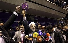 Iranian presidential candidate Hasan Rowhani, center, holds up a leaflet showing a key, the symbol of his campaign, during a rally in Tehran, Iran, Saturday, June 8 (photo credit: AP/Ebrahim Noroozi)