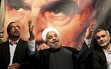 Hasan Rouhani, center, poses before a large portrait of the late Iranian revolutionary founder Ayatollah Khomeini, the day after being elected Iran's president, on June 15, 2013 (AP/Ebrahim Noroozi)