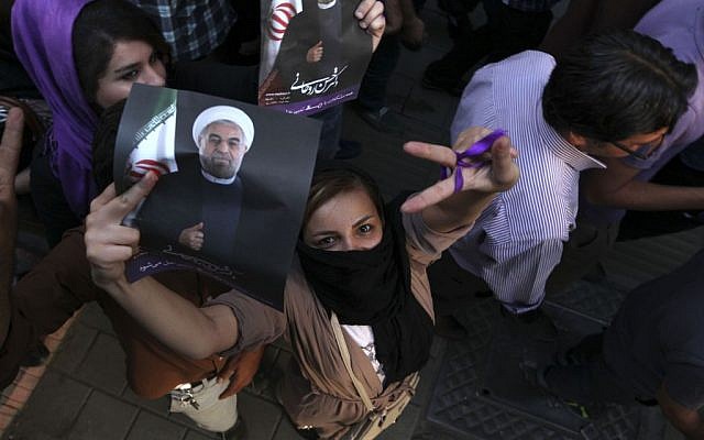 A female supporter of Hasan Rowhani flashes a victory sign as she holds his poster during a celebration gathering in Tehran, Saturday, June 15, 2013. Rowhani was declared the winner of Iran's presidential vote. (photo credit: AP Photo/Vahid Salemi) A female supporter of Hasan Rowhani flashes a victory sign as she holds his poster during a celebration gathering in Tehran, Saturday, June 15, 2013. Rowhani was declared the winner of Iran's presidential vote. (photo credit: AP Photo/Vahid Salemi)
