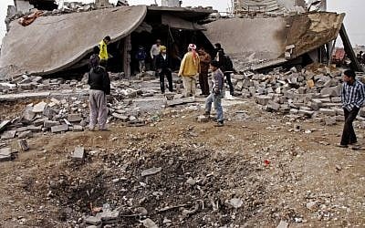 In this file photo taken on Dec. 17, 2012, people inspect the scene of a car bomb attack in al-Mouafaqiyah, a village inhabited by families from the Shabak ethnic group, near the city of Mosul (photo credit: AP)
