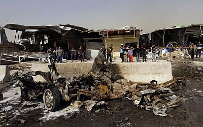 Illustrative photo of Iraqis inspecting the scene of a car bomb attack in the Ameen neighborhood of eastern Baghdad, Iraq (photo credit: AP/ Khalid Mohammed)