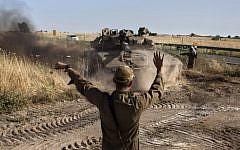 An Israeli soldier directs a tank near the Quneitra crossing with Syria on Thursday.(photo credit: AP/Sebastian Scheiner)