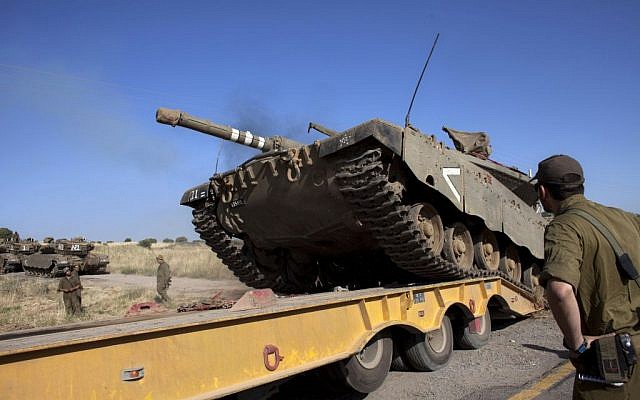 An Israeli tank is loaded onto a truck near the Quneitra crossing with Syria, on Thursday, June 6, 2013. (photo credit: AP/Sebastian Scheiner) An Israeli tank is loaded onto a truck near the Quneitra crossing with Syria, on Thursday, June 6, 2013. (photo credit: AP/Sebastian Scheiner)