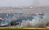 Smoke rises from a fire that resulted from fighting in the Syrian village of Quneitra, near the border with Israel, on June 6, 2013 (photo credit: AP/Sebastian Scheiner)