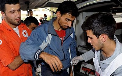 Members of the Lebanese Red Cross help a Syrian man who was wounded in Qusair, Syria, during battles between the rebels and the Syrian government forces, at a hospital in the Bekaa Valley, east of Beirut, Lebanon, on Saturday, June 8, 2013. (photo credit: AP/file photo)