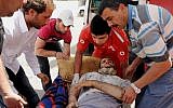 Members of the Lebanese Red Cross carry a Syrian man who was wounded in Qusair during battles between the rebels and Syrian government forces, Saturday, June 8, 2013 (photo credit: AP)