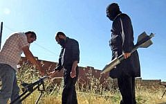 Syrian rebels preparing to fire locally made rockets, Tuesday, June 4, 2013 (photo credit: AP/Edlib News Network ENN)