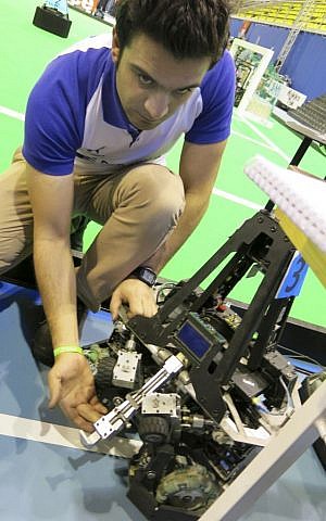 Mostafa Mahmoodi, in charge of mechanical systems for the robotics team from Iran's Qazvid Islamic Open University, shows off the kicking and passing device used by his mid-sized robots at the RoboCup in Eindhoven, Netherlands, on Thursday, June 27, 2013. (photo credit: AP Photo/Toby Sterling) Mostafa Mahmoodi, in charge of mechanical systems for the robotics team from Iran's Qazvid Islamic Open University, shows off the kicking and passing device used by his mid-sized robots at the RoboCup in Eindhoven, Netherlands, on Thursday, June 27, 2013. (photo credit: AP Photo/Toby Sterling)