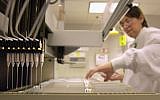 A technician loads patient samples into a machine for testing at Myriad Genetics Friday, May 31, 2002, in Salt Lake City. (photo credit: AP Photo/Douglas C. Pizac)