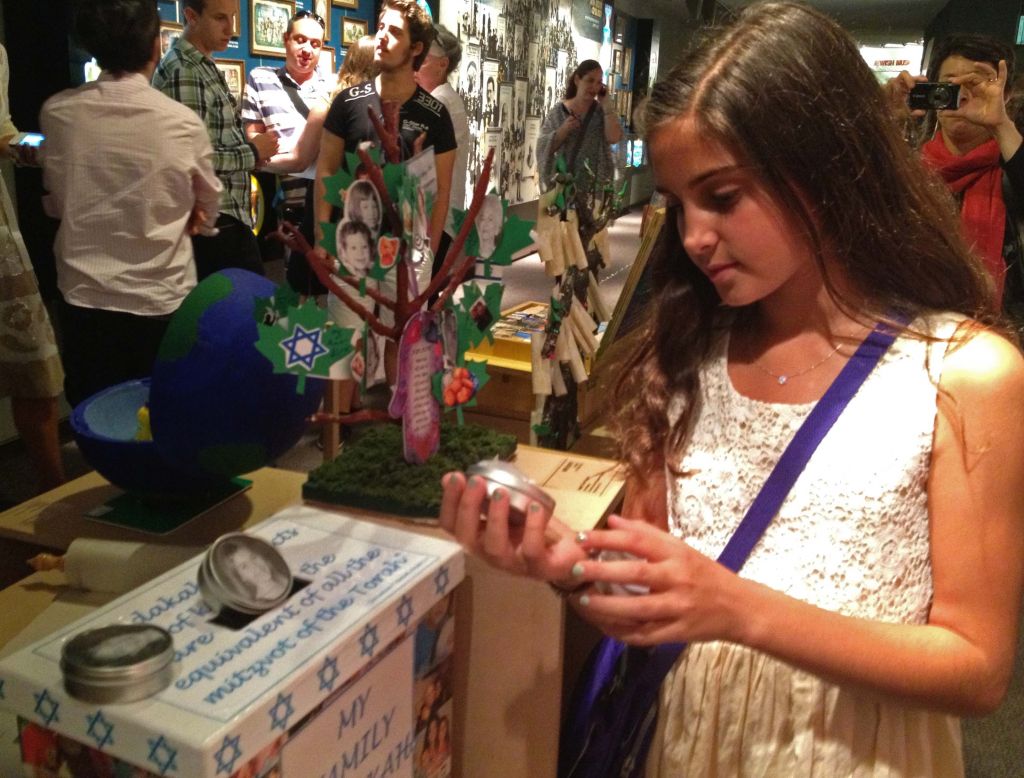 Deryn Klein, a fifth-grade student from San Diego, CA, looks over her award-winning artwork for 'My Family Story,' a competition held by the Beit Hatfutsot, the Museum of the Jewish People (photo credit: Leeor Bronis/Times of Israel)