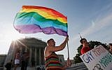 Illustrative photo. Gay rights supporter waving a rainbow flag outside the US Supreme Court building in Washington following its ruling expanding gay rights, June 26, 2013. (Win McNamee/Getty Images via JTA)