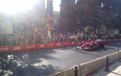 A Formula 1 race car zips past Jerusalem's iconic YMCA building on Thursday as part of the Formula Jerusalem exhibition. (photo credit: Ilan Ben Zion/Times of Israel staff)