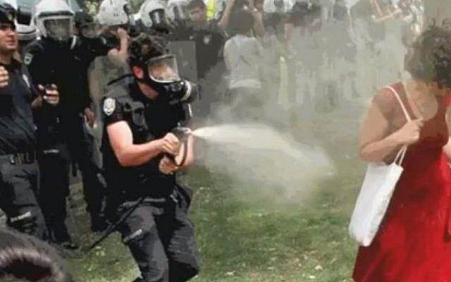 The woman attempts to escape the tear-gas cloud (photo credit: Youtube screenshot)