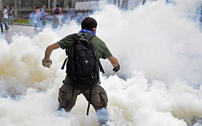 A man runs as riot police use tear gas and pressurized water to quash a sit-in protest to try and prevent the demolition of trees at an Istanbul park, Turkey, Friday, May 31, 2013. Police moved in at dawn Friday to disperse the crowd on the fourth day of the protest against a contentious government plan to revamp Istanbul’s main square, Taksim. (AP Photo)