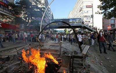 Turkish youths shout slogan " Tayyip, resign! " as they clash with security forces in Ankara, Turkey, Saturday, June 1, 2013.  (Photo credit: AP/Burhan Ozbilici)