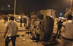 Protesters look at a destroyed car during a rally at the Taksim Square in Istanbul early Sunday, June 2, 2013. (photo credit: AP/Thanassis Stavrakis)