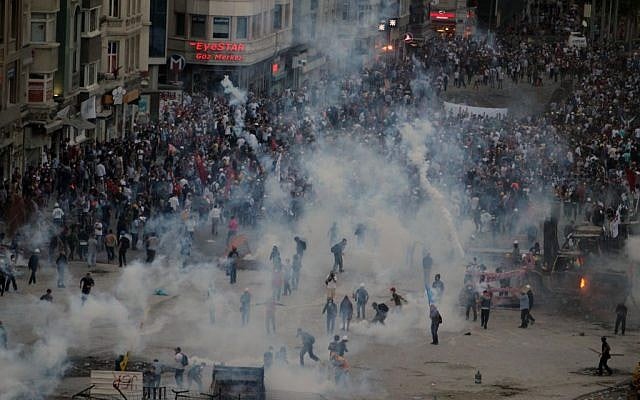 Police shoot tear gas ot protesters in Taksim Square Tuesday. (photo credit: AP/Thanassis Stavrakis) Police shoot tear gas ot protesters in Taksim Square Tuesday. (photo credit: AP/Thanassis Stavrakis)