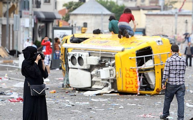 A tourist takes photo the damage at Taksim square of Istanbul, on Sunday, June 1, 2013.  (photo credit: AP Photo/Thanassis Stavrakis)