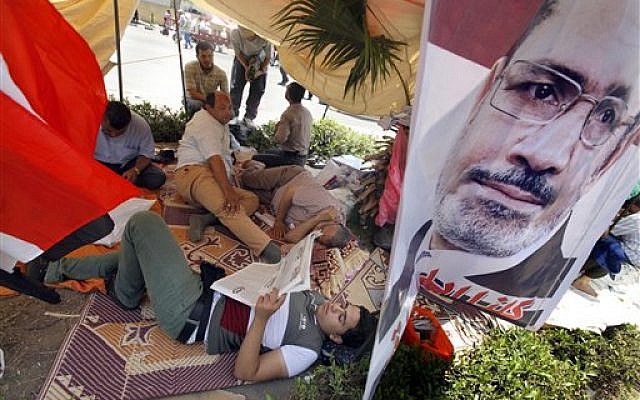 Supporters of Egypt's Islamist President Mohammed Morsi rest at their tent with a poster of the president at a public square outside the Rabia el-Adawiya mosque near the presidential palace in Cairo, Saturday, June 29, 2013 (photo credit: AP Photo/Amr Nabil) Supporters of Egypt's Islamist President Mohammed Morsi rest at their tent with a poster of the president at a public square outside the Rabia el-Adawiya mosque near the presidential palace in Cairo, Saturday, June 29, 2013 (photo credit: AP Photo/Amr Nabil)
