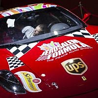 A worker cleans a Ferrari racing car as he prepares it for display prior to the opening of a racing car and motorcycle exhibition held at the Old Jerusalem Train Station, on June 9, 2013 (photo credit: Flash90)