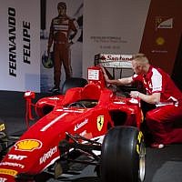 A Ferrari technical crew member prepares a Ferrari Formula One racing cars for display prior to the opening of a racing car and motorcycle exhibition held at the Old Jerusalem Train Station, on June 9, 2013 (photo credit: Flash90)
