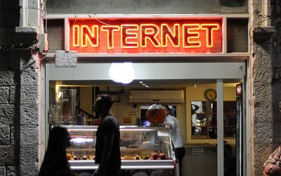 Pedestrians pass a cafe with internet on Jaffa St, Jerusalem on October 21, 2012. (photo credit: Louis Fisher/Flash90)
