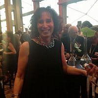 NYer Jo-Ann Mort in a drapy black tank dress and chunky chain (photo credit: Sarah Tuttle-Singer/Times of Israel)