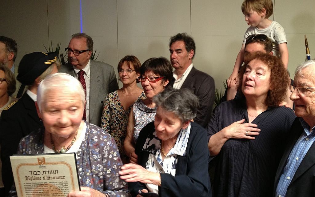 A member of the Le Guellec family holds up the righteous gentile certificate awarded posthumously to Alfred and Augustine Le Guelllec (photo credit: Elhanan Miller/Times of Israel)