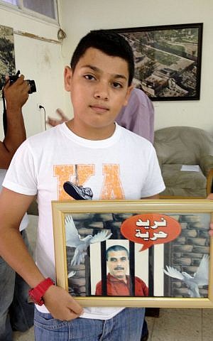 Ayman Daqqa holds up a framed portrait of his uncle Walid (photo credit: Elhanan Miller/Flash90)