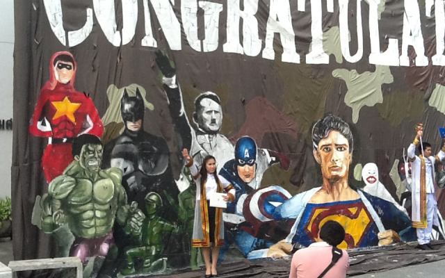 Passersby performing the Nazi salute in front of a mural  depicting Adolf Hitler alongside assorted superheroes in Thailand's Chulalong University (photo credit: Courtesy/Simon Wiesenthal center)