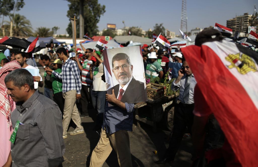 A supporter of Egypt's Islamist President Mohammed Morsi carries a photo of him during a rally, in Nasser City, Cairo, Egypt, Wednesday, July 3, 2013. (photo credit: AP/Hassan Ammar) A supporter of Egypt's Islamist President Mohammed Morsi carries a photo of him during a rally, in Nasser City, Cairo, Egypt, Wednesday, July 3, 2013. (photo credit: AP/Hassan Ammar)