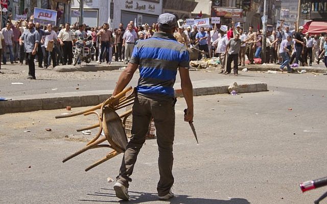 An Egyptian opposition protester holds a chair and knife during a clash between supporters and opponents of President Mohammed Morsi in downtown Damietta, Egypt, Wednesday, July 3, 2013 (photo credit: AP/Hamada Elrasam) An Egyptian opposition protester holds a chair and knife during a clash between supporters and opponents of President Mohammed Morsi in downtown Damietta, Egypt, Wednesday, July 3, 2013 (photo credit: AP/Hamada Elrasam)