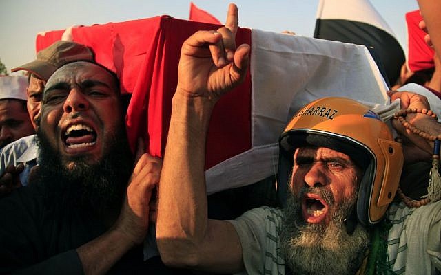 Supporters of Egypt's ousted President Mohammed Morsi chant angry slogans as they carry a coffin covered with the national flag, of a man killed after Egyptian troops opened fire on mostly Islamist protesters marching on a Republican Guard headquarters Friday, in Cairo, Saturday, July 6, 2013 (photo credit: AP/Khalil Hamra) Supporters of Egypt's ousted President Mohammed Morsi chant angry slogans as they carry a coffin covered with the national flag, of a man killed after Egyptian troops opened fire on mostly Islamist protesters marching on a Republican Guard headquarters Friday, in Cairo, Saturday, July 6, 2013 (photo credit: AP/Khalil Hamra)